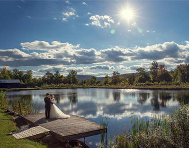 couple standing on dock near pond